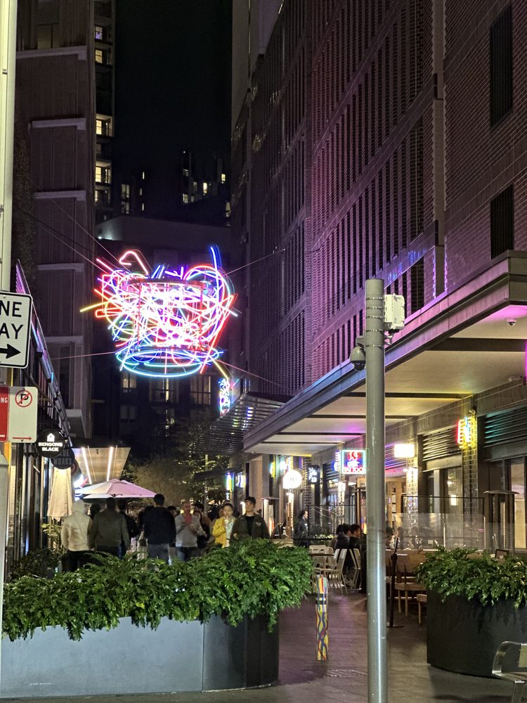 Neon sculpture and nightlife along a Chinatown street